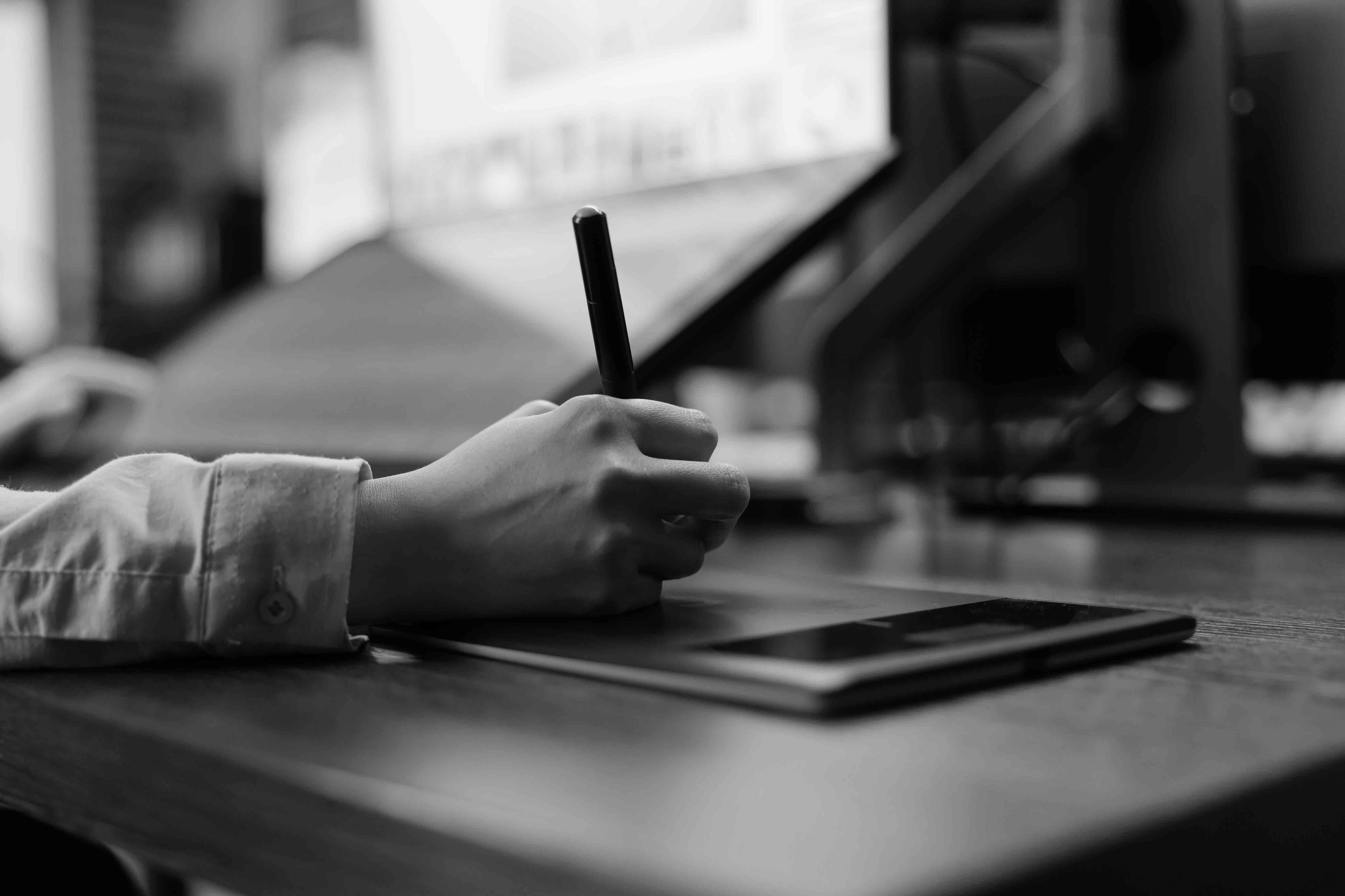 Eine Hand mit einem Stift designt eine Auspuffanlage bei Zard auf einem Tablet.